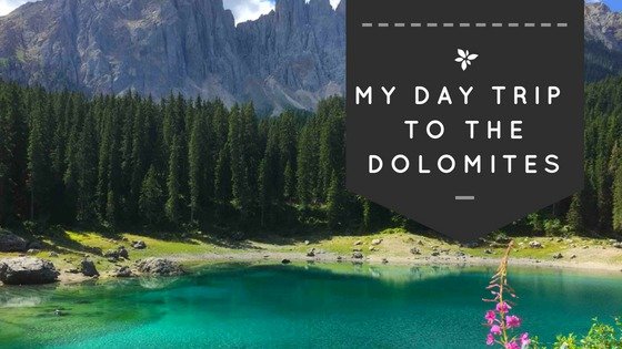 This is Lake Carezza in South Tyrol, Italy which is also known as the rainbow lake due to its spectacular colours. The story goes that a sorcerer once hurled a rainbow into the lake, since then it has shimmered that colourful. In the background you can see the Alps and the Dolomites.